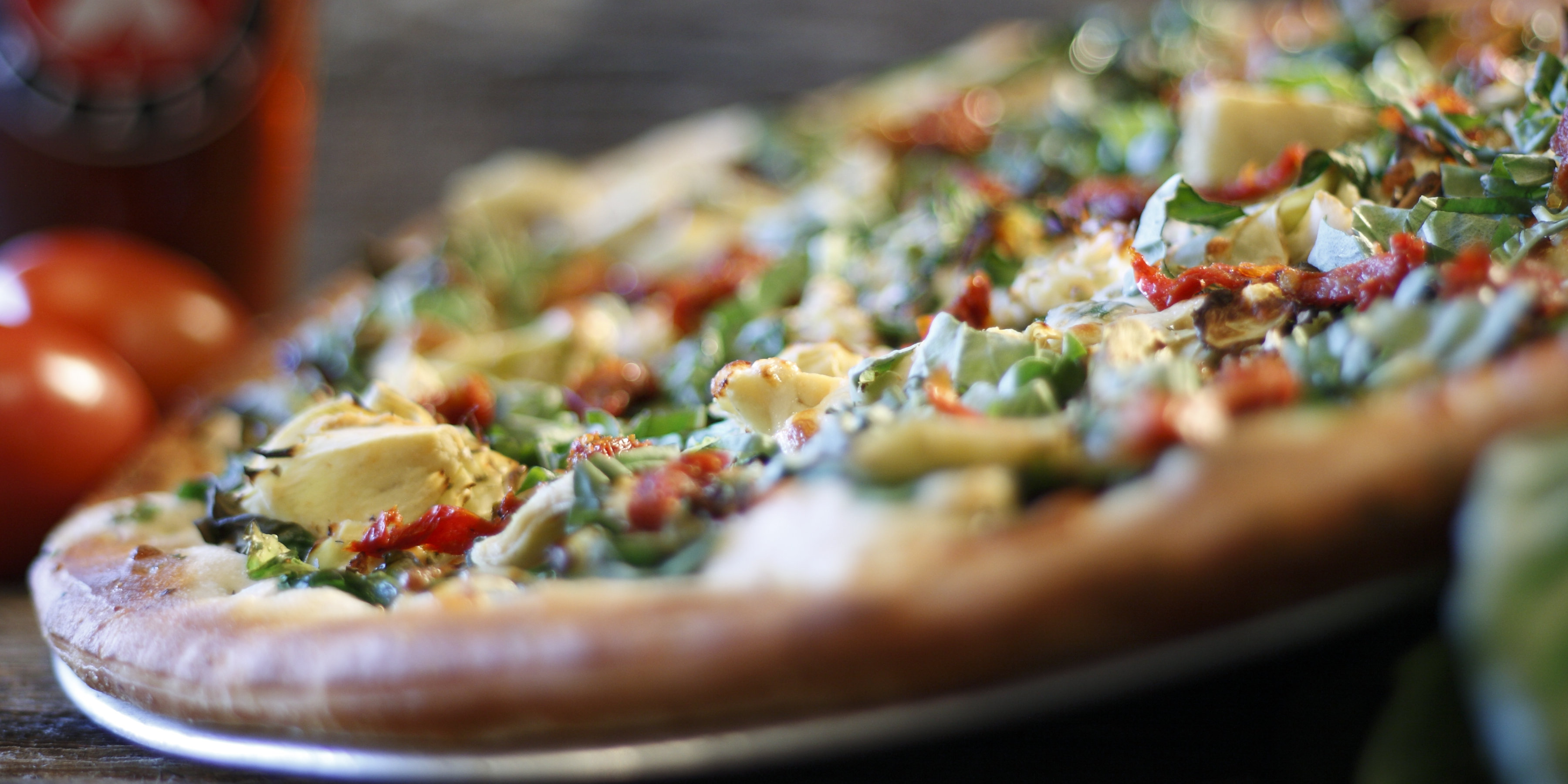 Extreme Pizza signature pizza with artichokes, sun-dried tomatoes and fresh greens